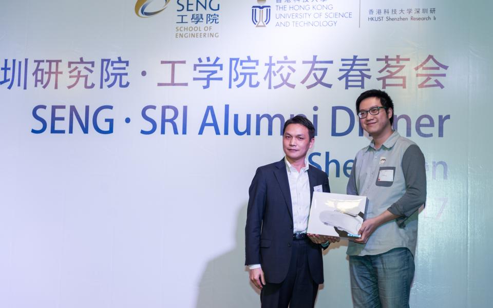 (Left) SENG alumnus Dr Peng Huajun, 2005 PhD in Electronic and Electrical Engineering, sponsors a lucky draw prize of "Goovis VR Glasses" and takes a photo with the winner