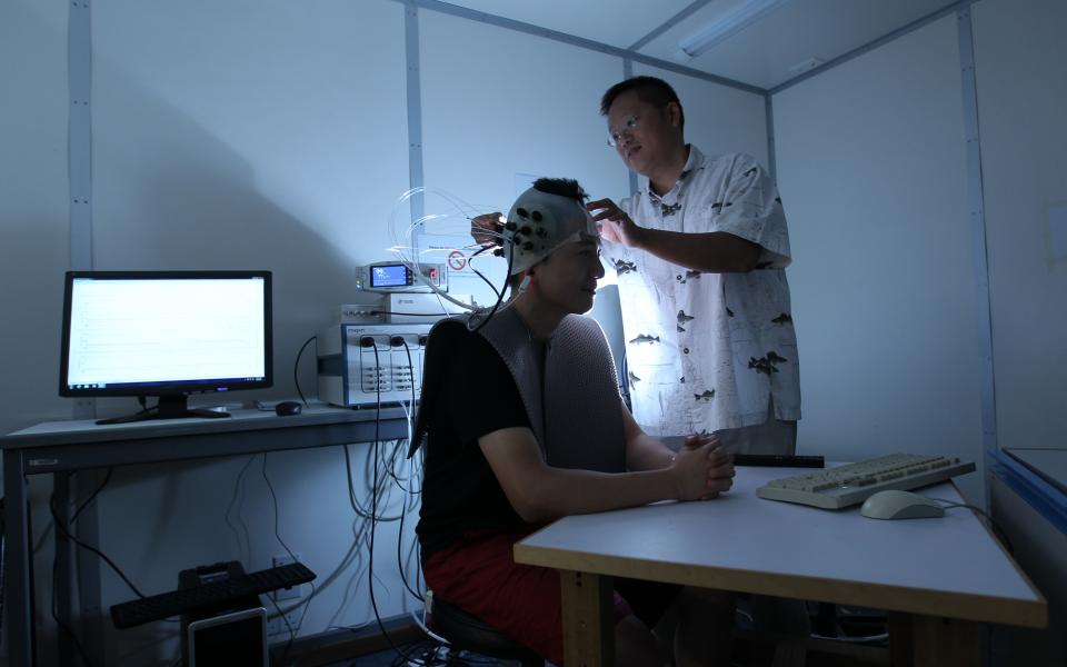 Prof. So setting up a near infra-red spectroscopy system to measure brain responses.