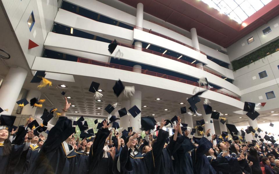 Graduates toss their hats in jubilation as the Congregation concludes.