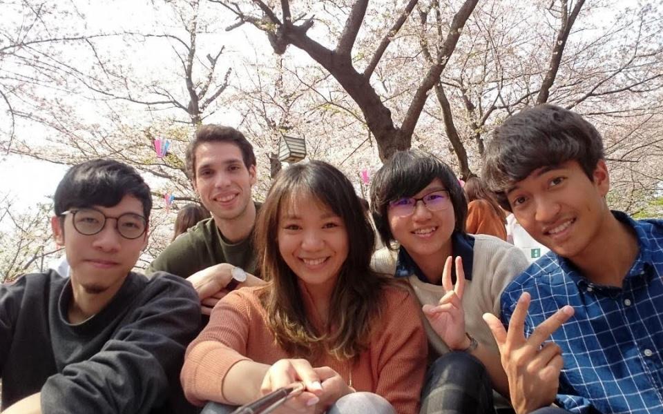 Alumna CHAU Wing-In (second right) gets along well with her friends and colleagues in Japan.  They engaged in the Japanese practice of Hanami – having a picnic and enjoying the cherry blossoms.