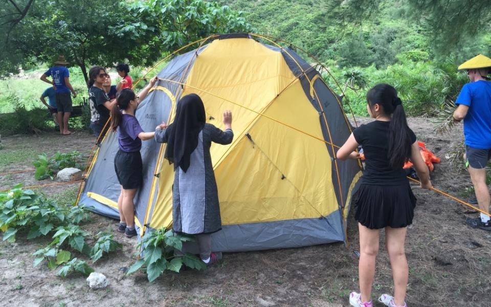 Students set up tent at campsite