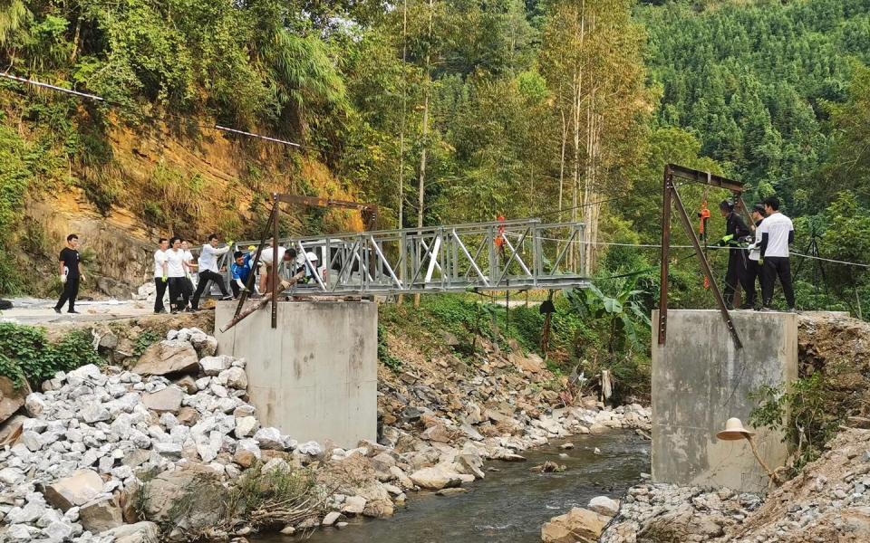 Student volunteers pushed the bridge structure with the assistance of machinery.