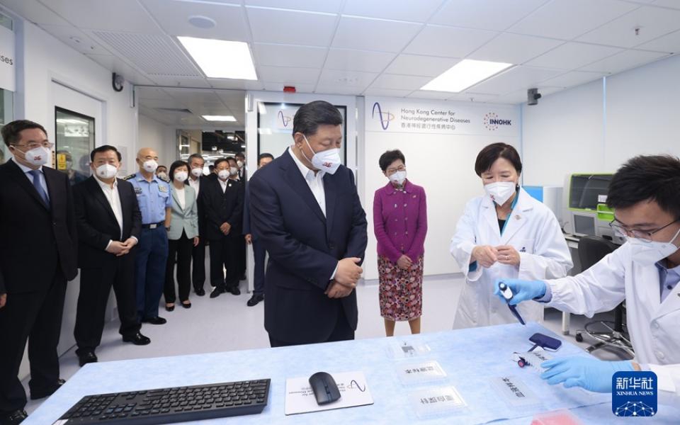 President XI Jinping (Fourth right), Former Chief Executive of the HKSAR Carrie LAM Cheng Yuet-Ngor (Third right), and other officials from the Central Government and the HKSAR Government listen to a briefing by Prof. Nancy IP (Second right) on how the simple blood test for early detection and classification of Alzheimer’s disease is conducted. Photo by Xinhua News