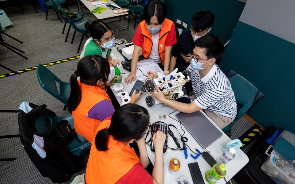 Participants made final adjustments to their robot on the competition day in July. 