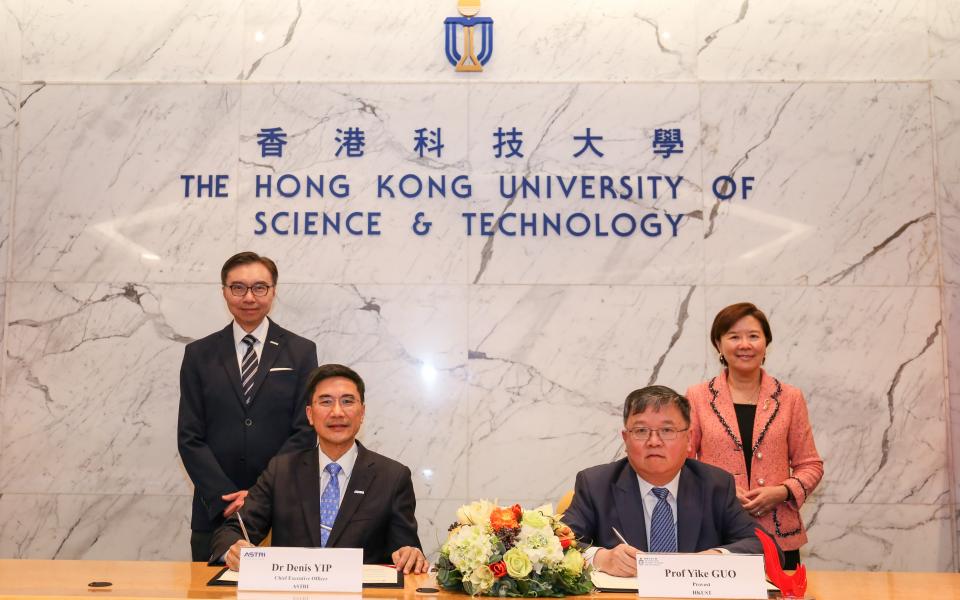 ASTRI Chief Executive Officer Dr. Denis Yip (front left) and HKUST Provost Prof. Yike GUO (front right) sign the agreement under the witness of HKUST President Prof. Nancy IP (back row first right) and Chairman of ASTRI Board of Directors Ir. Sunny Lee (back row first left).