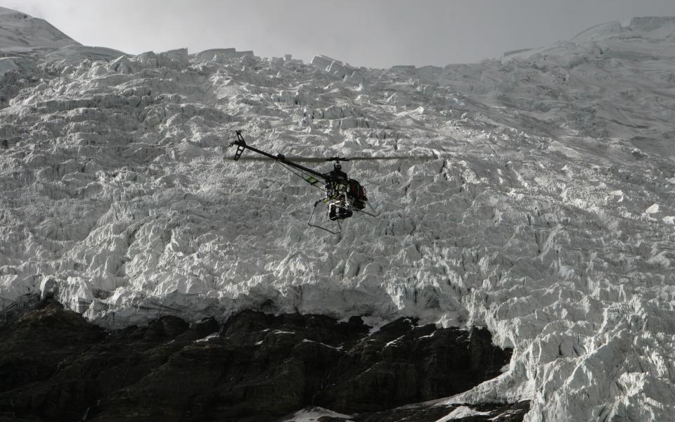 The helicopter flying over a glacier