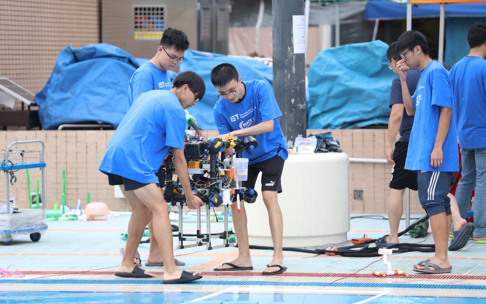 Members of the ROV sub-team move their robot to get ready for the mission.