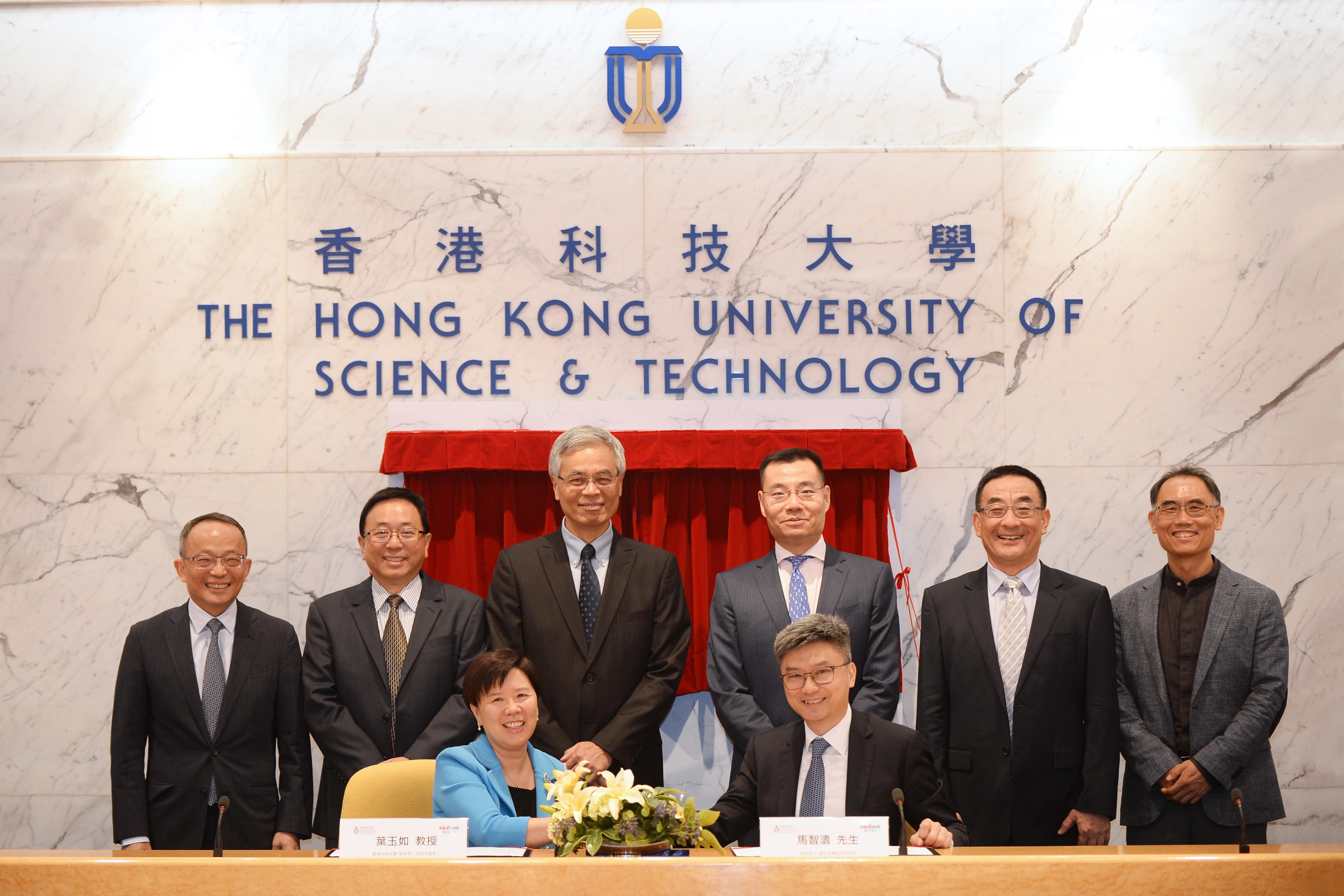 Prof. Nancy IP (front left), HKUST Vice-President for Research and Development, and Mr. Henry MA (front right), Executive Vice-President and Chief Information Officer of WeBank sign the agreement.