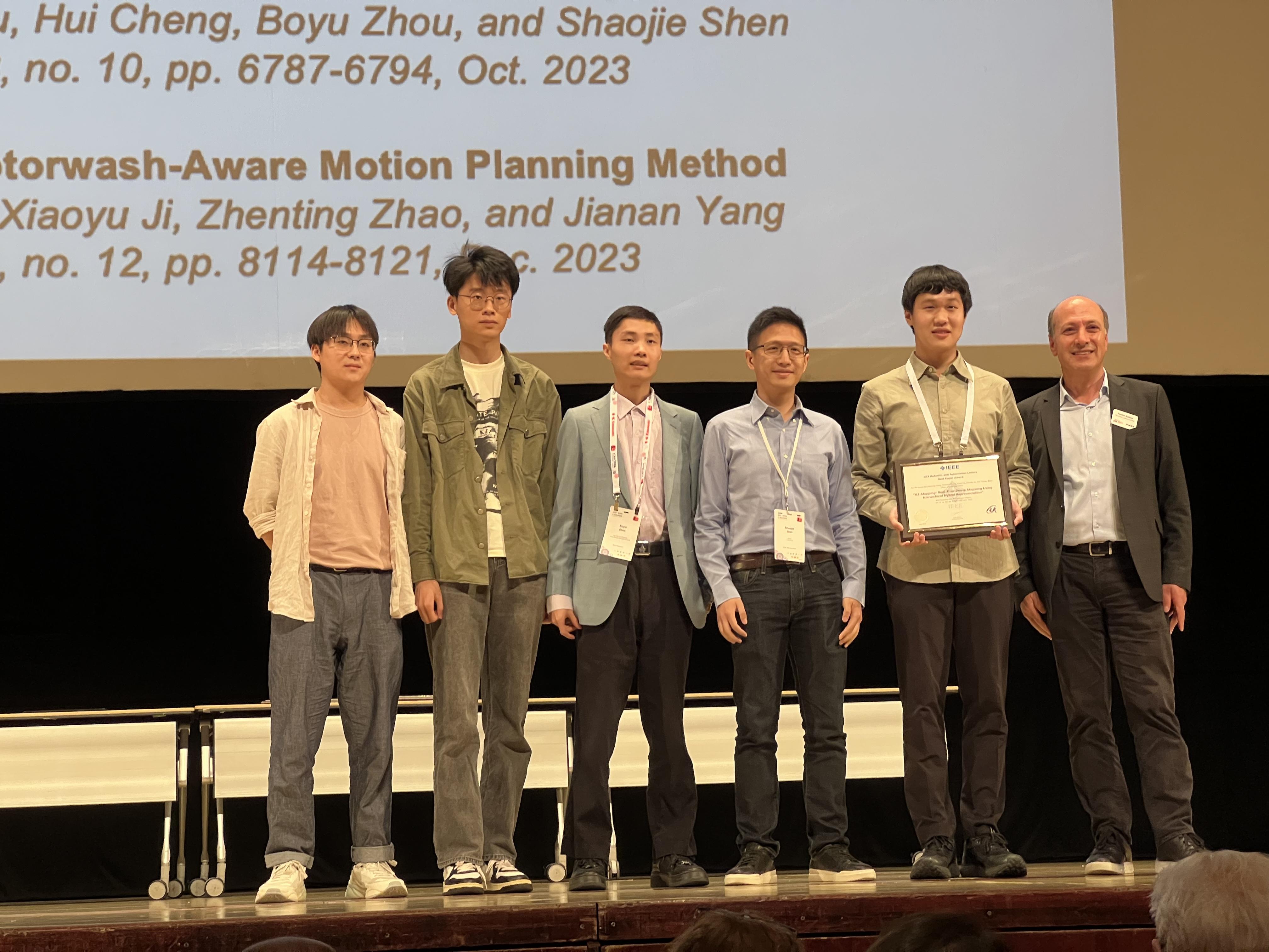 Prof. Shen Shaojie (third right), his current PhD students Jiang Chenxing (first author, second right), Liu Peize (first left) and Yu Zehuan (second left), and former PhD student Dr. Zhou Boyu (third left) received an IEEE Robotics and Automation Letters Best Paper Award at the IEEE International Conference on Robotics and Automation 2024.